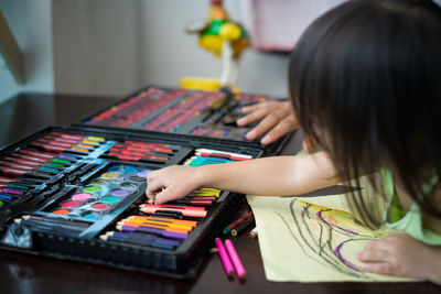 Rear view of girl playing with toy on table