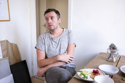 Man sitting by food on table at home