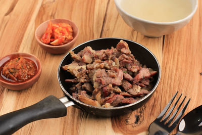 Beef sei is indonesia traditional smoked beef, served with boiled cassava leaves and sambal luat 