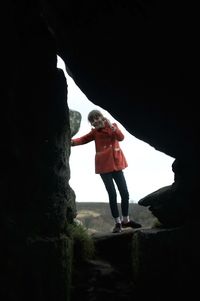 Rear view of woman standing on rock