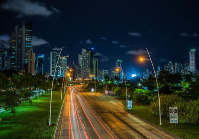 Light trails on road against sky at night