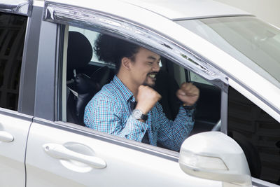 Businessman clenching fists in car