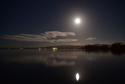 Scenic view of lake against sky at night