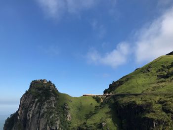 Low angle view of mountain against blue sky