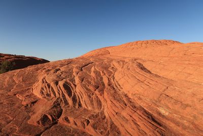 Low angle landscape of multi layered orange rock formation in snow canyon state park in utah