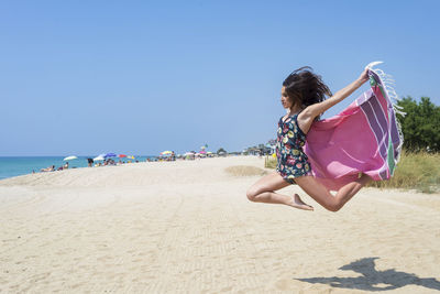 Teenage girl jumping at beach