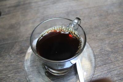High angle view of black tea served on wooden table