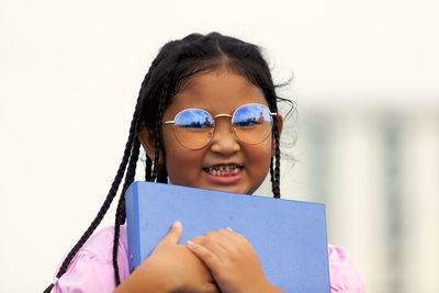 Portrait of a smiling girl holding camera