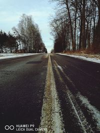 Road amidst trees against sky