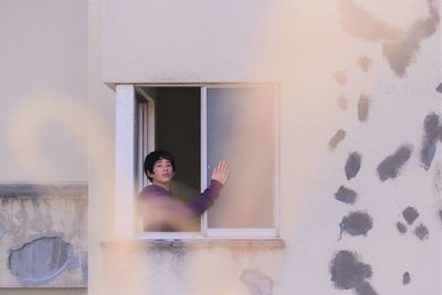 Portrait of woman against wall at home