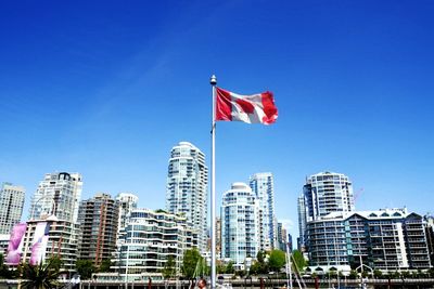 Low angle view of flag against blue sky