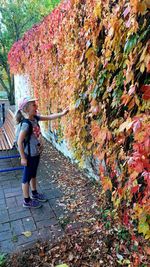 Full length of woman with autumn leaves