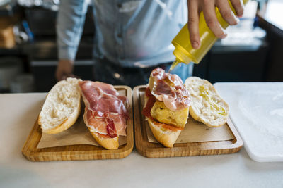 Chef pouring olive oil on sandwiches in a restaurant