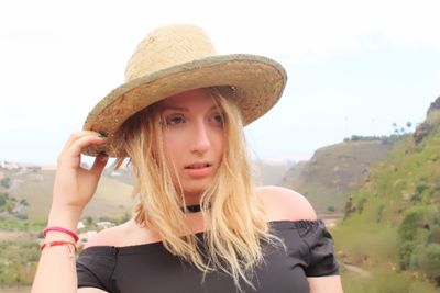 Portrait of beautiful young woman against sky