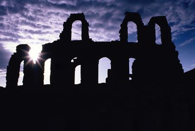 Low angle view of silhouette historic building against sky