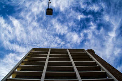 Low angle view of office building against cloudy sky