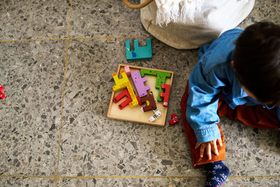 High angle view of boy playing with teddy bear