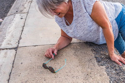 High angle view of woman holding hands on footpath