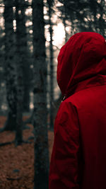 Rear view of person wearing hood while standing in forest