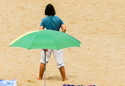 Rear view of woman standing on beach