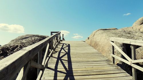 Steps leading towards beach against clear blue sky