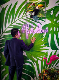 Man standing by graffiti on wall