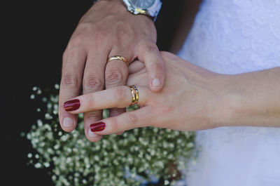 Close-up of bride and groom holding hands