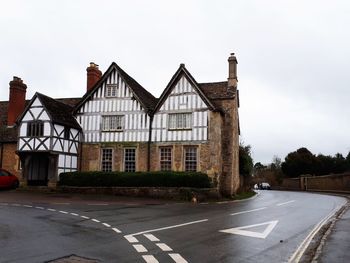 Road by building against sky