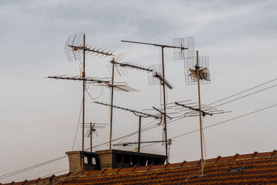 Low angle view of antennas against sky