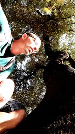 Low section of woman standing on tree trunk