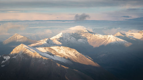 Scenic view of snowcapped mountains against sky during sunset