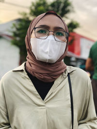Close-up woman wearing mask standing outdoors