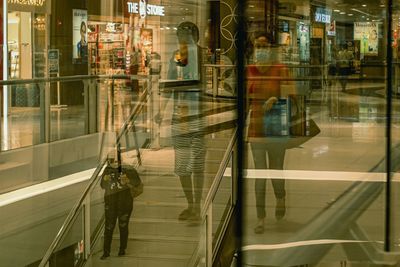 Reflection of man on glass window in city