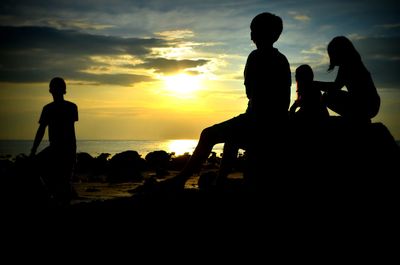 Silhouette of people looking at sunset