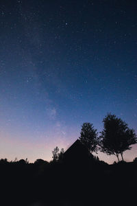 Silhouette trees against sky at night