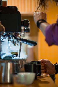 Midsection of woman holding coffee in cafe