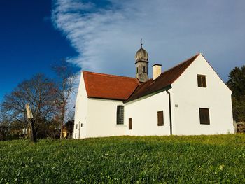 Traditional building on field against sky