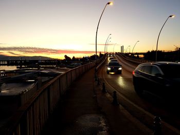 Traffic on road at sunset