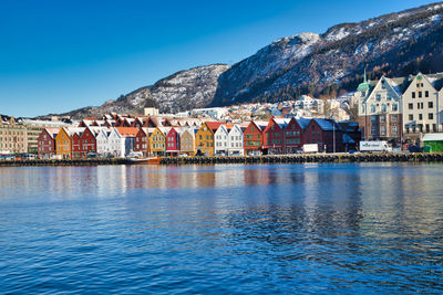 Houses by buildings in town against sky