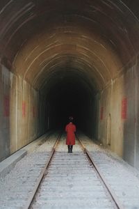 Rear view of man walking in tunnel