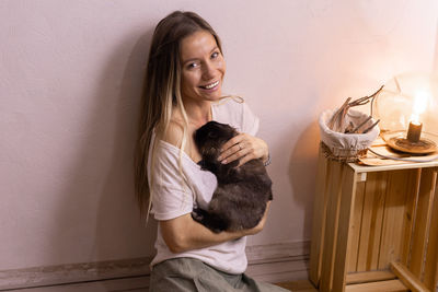 Portrait of young woman using mobile phone at home