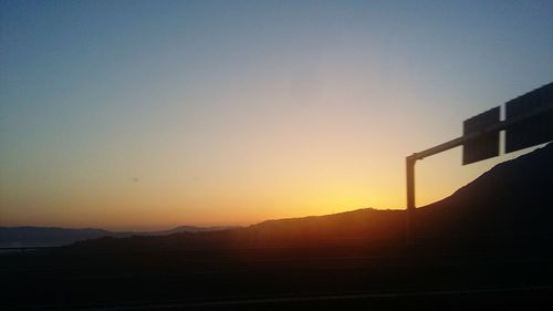 Scenic view of silhouette mountains against clear sky during sunset