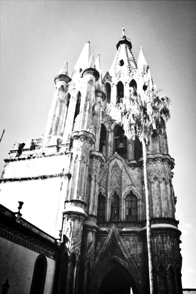 architecture, low angle view, religion, church, place of worship, built structure, building exterior, spirituality, cathedral, cross, clear sky, arch, sky, no people, day, history, outdoors, window