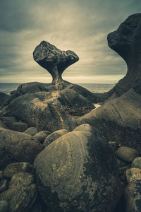 Sculpture on rock against sky