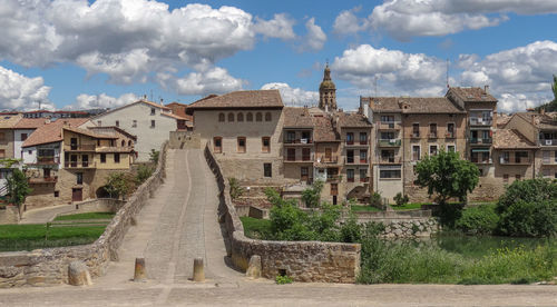 Buildings in city against cloudy sky