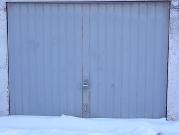 Closed door of snow covered wall