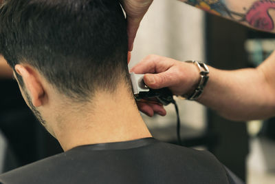 Hairdresser cutting man hair