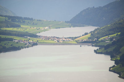 Scenic view of river by mountains against sky