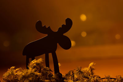 Close-up of silhouette toy against sky during sunset