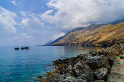 Scenic view of mountains against cloudy sky